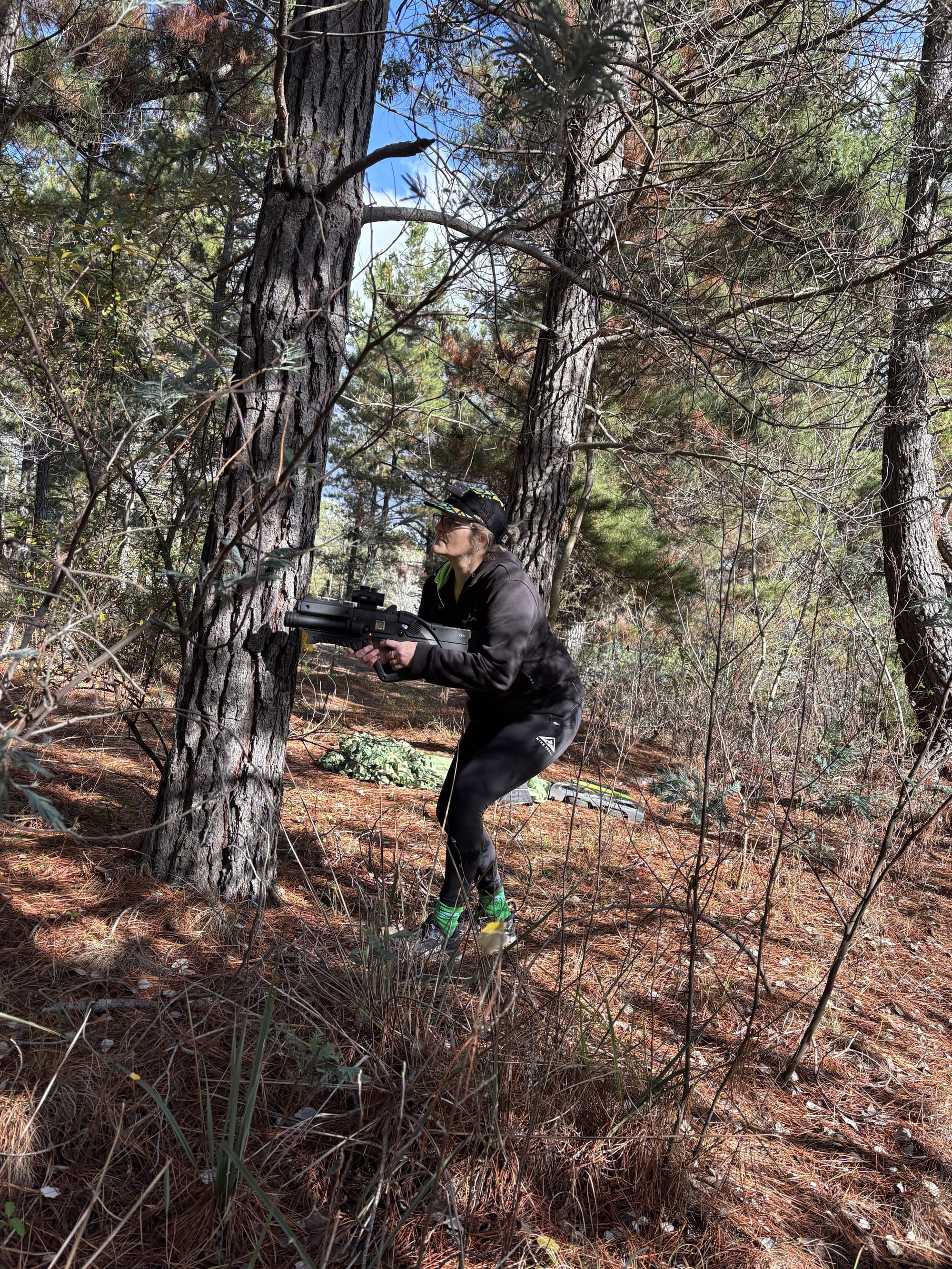 Player taking position behind a pine tree